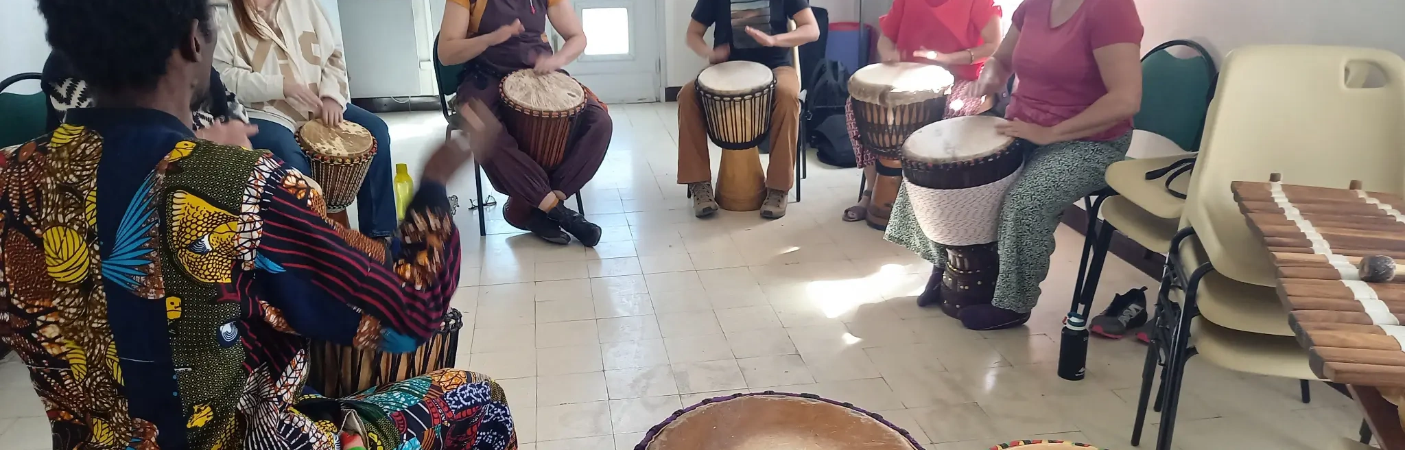 Groupe réuni autour des percussions africaines pendant un cours